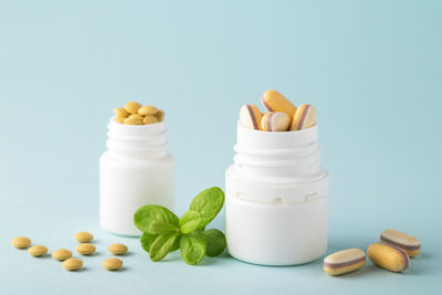 Vitamins and herbal supplements in jars with a green plant. dietary supplements.