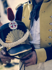 Midsection of soldier holding cap