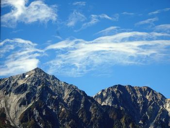 Low angle view of mountains against blue sky