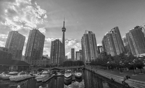 Yachts moored on river against cn tower amidst modern buildings in city