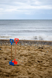 Scenic view of beach against cloudy sky