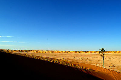 Scenic view of desert against clear blue sky