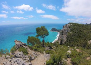 Scenic view of sea by cliff against sky