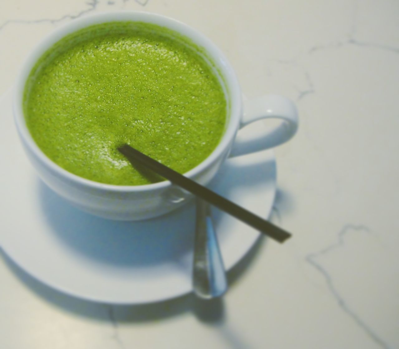 food and drink, indoors, refreshment, drink, still life, selective focus, freshness, high angle view, green color, close-up, tea cup, table, ready-to-eat, green tea, healthy eating, non-alcoholic beverage, cup, indulgence, green, beverage, temptation, serving size, hot drink, espresso