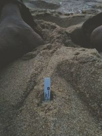 Close-up of hand on sand at beach