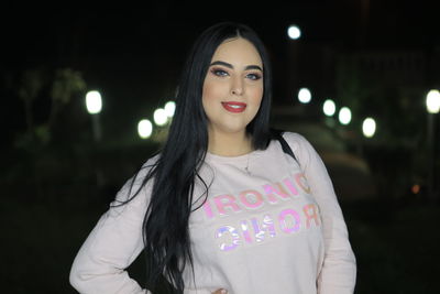 Portrait of beautiful woman standing at night