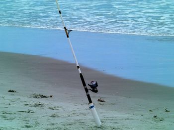 Fishing rod on sand at beach