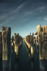 Panoramic view of wooden posts in lake against sky