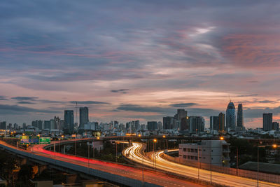 High angle view of light trails on bridge against sky during sunset in city