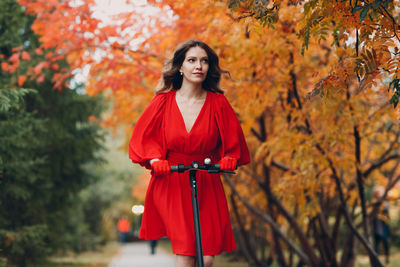 Woman riding push scooter in park