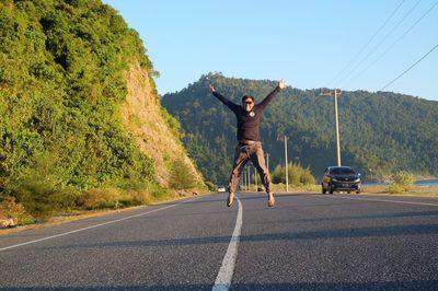 Full length of man skateboarding on road