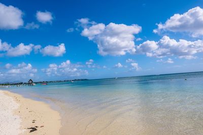 Scenic view of beach against blue sky