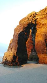 Rock formation by sea against sky