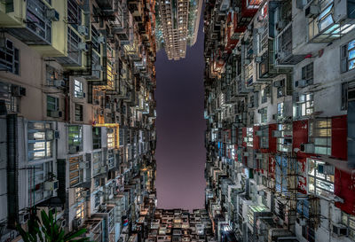 Directly below shot of buildings against sky at night