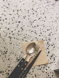High angle view of eating utensils on marble