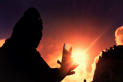 Silhouette statue at lantau island against sky during sunset