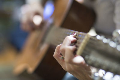 Midsection of man playing guitar