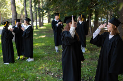 Rear view of students standing in park