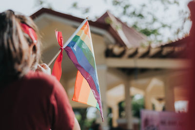 Midsection of woman holding multi colored umbrella