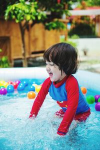 Boy playing with ball in swimming pool