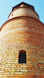 Low angle view of brick wall against building