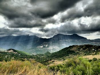 Scenic view of mountains against cloudy sky