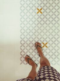 Low section of woman standing on tiled floor