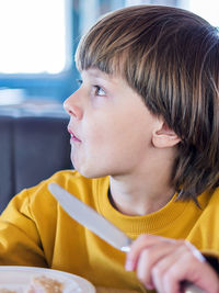 Close-up of boy eating food at cafe