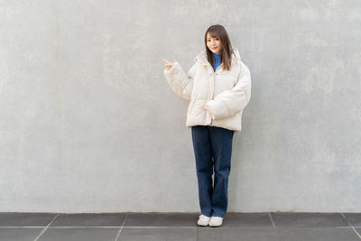 Young man standing against wall