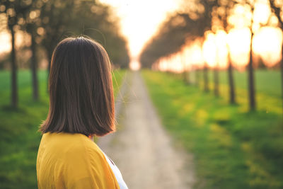 Rear view of woman standing on field