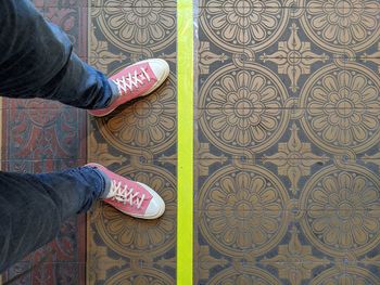 Low section of man standing on tiled floor