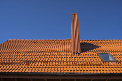 Low angle view of roof of building against clear blue sky