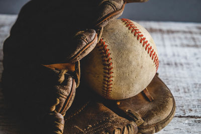 Close-up of baseball gloves and ball on table