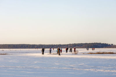 People ice skating at a winter day on a natural lake