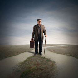 Full length portrait of man standing on land against sky