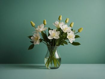 Close-up of flowers in vase against wall