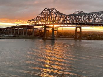 Bridge over river against sky during sunset