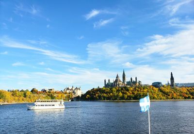 Boat in river against cloudy sky