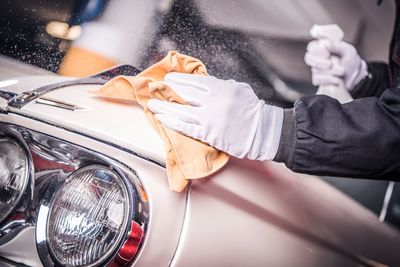 Midsection of person cleaning car