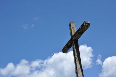 Low angle view of old wooden post against sky