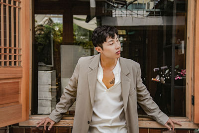 Woman looking through window at entrance of building