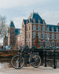 Bicycle by building against sky