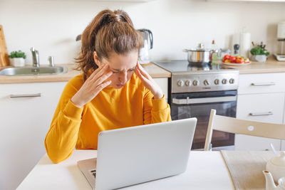 Side view of boy using laptop at home