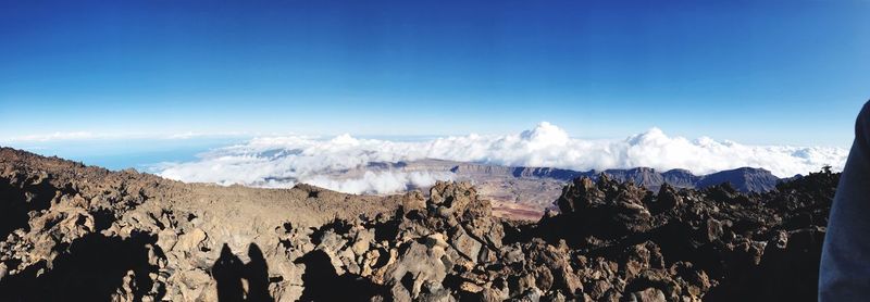 Panoramic view of mountains against blue sky