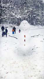 People on snow covered trees during winter