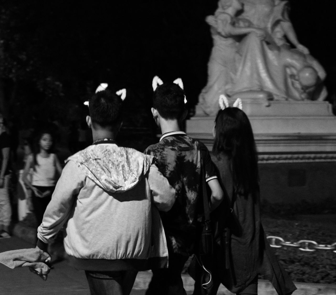 group of people, men, real people, women, child, representation, lifestyles, people, human representation, night, girls, sculpture, three quarter length, art and craft, boys, leisure activity, statue, rear view, focus on foreground, creativity