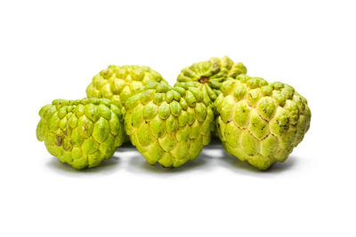 Close-up of green fruits against white background