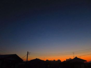 Low angle view of silhouette buildings against clear sky