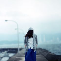 Woman face covered with hair standing on walkway