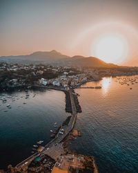 High angle view of city at seaside during sunset